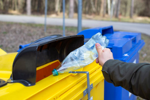 istock Person (only hand in the photo) puts PET (Polyethylene terephthalate) bottle in to recycling container 1219432192