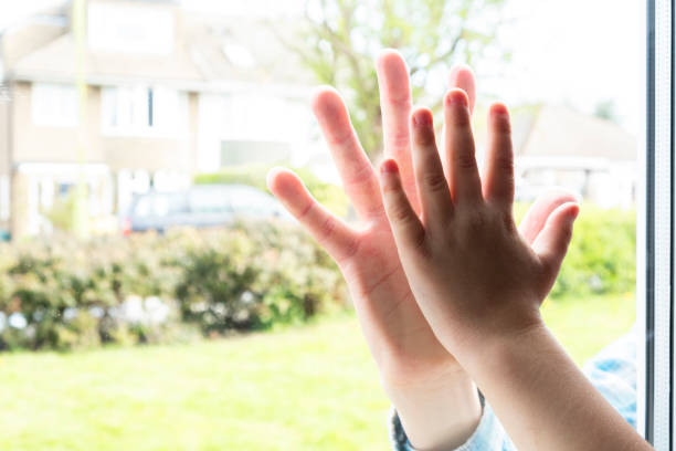 istock Father and son`s hands separated by glass 1219434028
