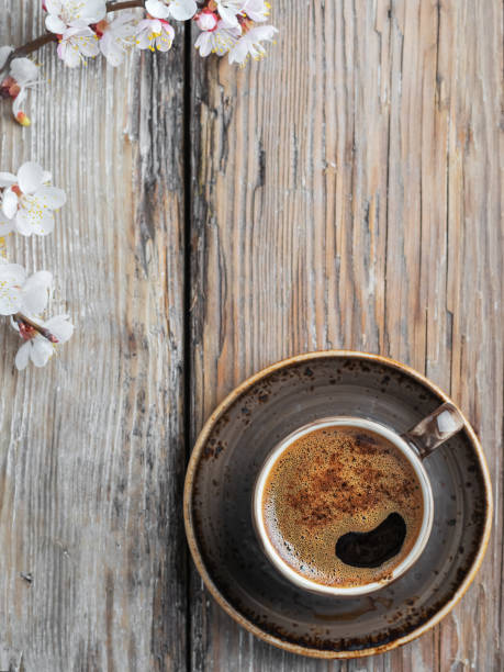 cup of fresh made coffee and spring branches of white flowers of cherry on a vintage wooden background, top view flat lay. - coffee top view imagens e fotografias de stock
