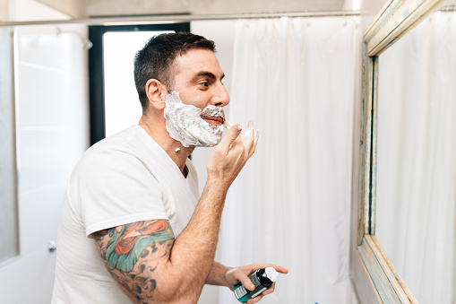 Man shaving in bathroom