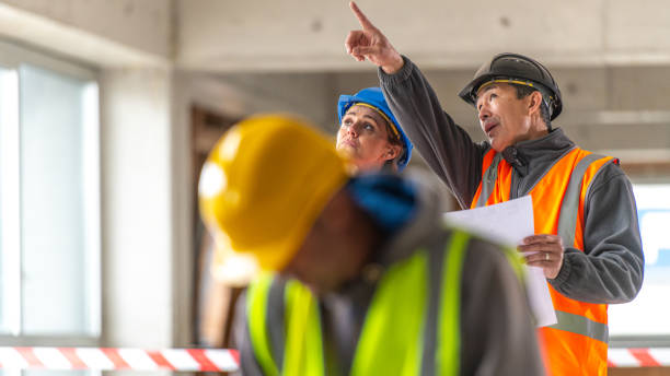 istock Asian Architect pointing with his hand while talking to his female colleague on a construction site 1219437972