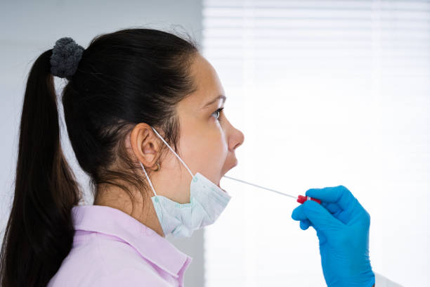 istock Doctor Taking Mouth Fluid Swab Sample 1219438037