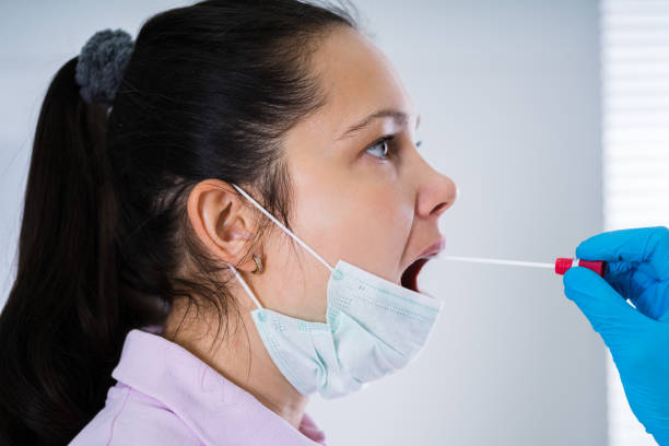 istock Doctor Taking Mouth Fluid Swab Sample 1219438078