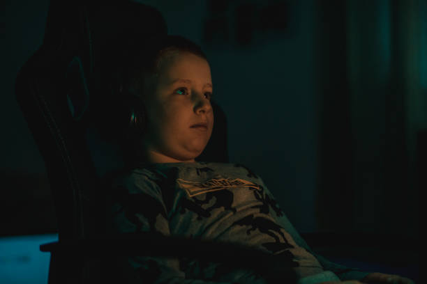 istock Young boy playing video games at home 1219438341