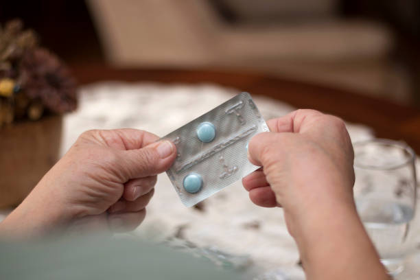 istock Close up of unrecognizable senior person taking a pill. 1219441072