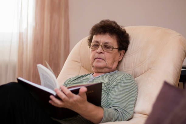 istock Senior woman sitting at home reading 1219441620