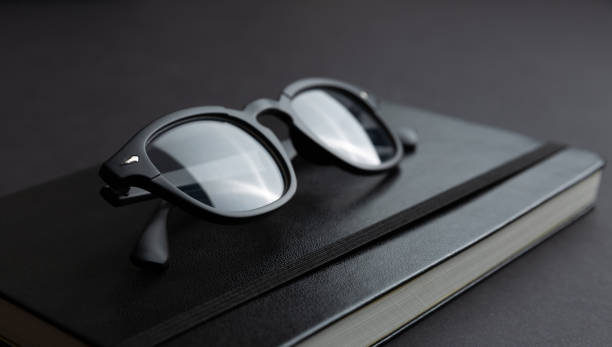 istock Closeup view of trendy black eyeglasses on trendy notebook. 1219441882