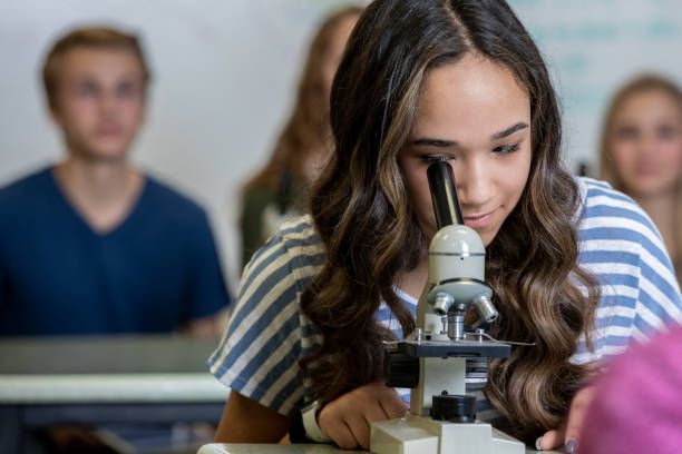 istock Teenage high school female student using microscope 1219442346