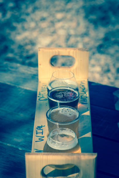 Mixed of hand-crafted beverages on tasting tray paddle with beer name in natural setting