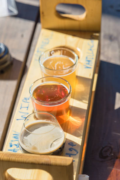 Mixed of hand-crafted beverages on tasting tray paddle with beer name in natural setting