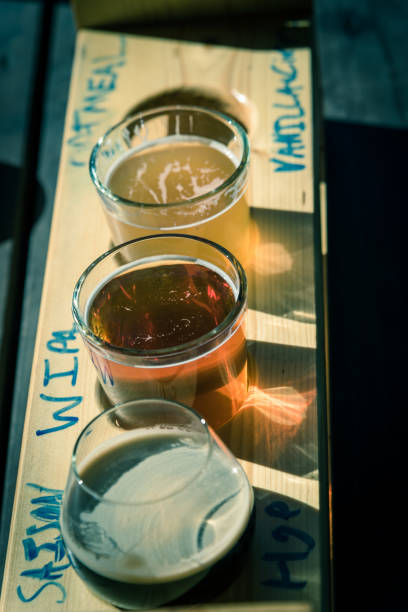 Mixed of hand-crafted beverages on tasting tray paddle with beer name in natural setting