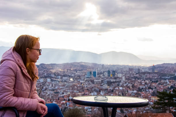 istock Woman sitting and drinking coffee above Sarajevo 1219445374