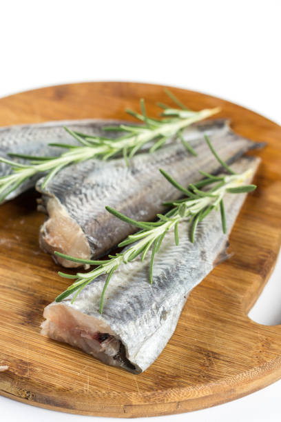 ローズマリーの枝と新鮮な生のハケ魚 - rosemary herb isolated ingredient ストックフォトと画像