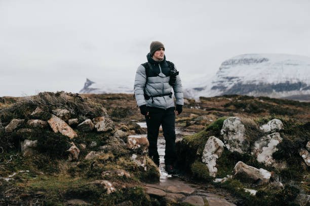 istock Man hikes through snowy mountainous landscape 1219453201