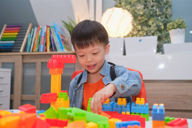 istock Asian kindergarten boy playing blocks with colorful plastic blocks indoor at home, Educational toys for young children, Stay home Stay safe Have fun concept 1219453319