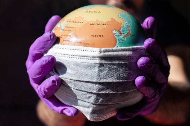 istock World Epidemic Danger. Mask protecting the planet. Black background 1219454214