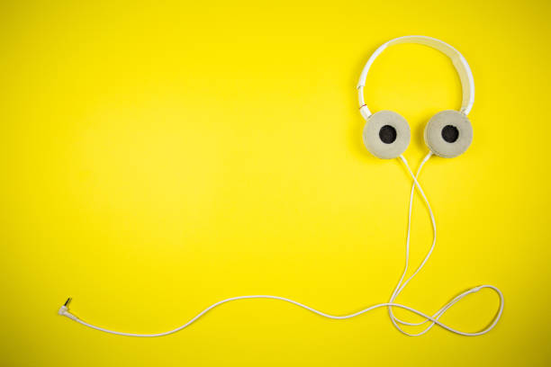 istock White audio headphones with a 3.5 mm wire on a yellow background 1219454267