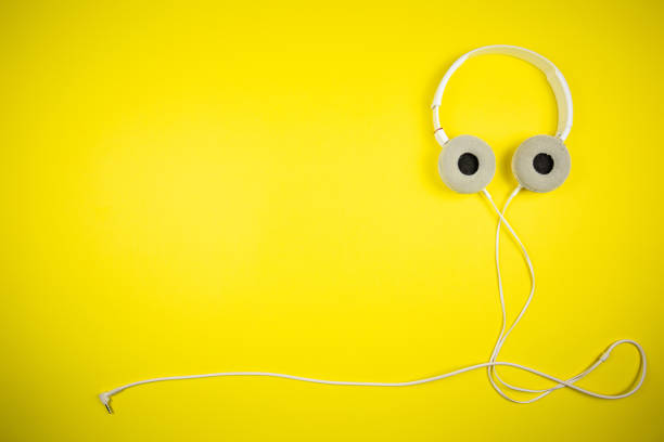 istock White audio headphones with a 3.5 mm wire on a yellow background 1219454558
