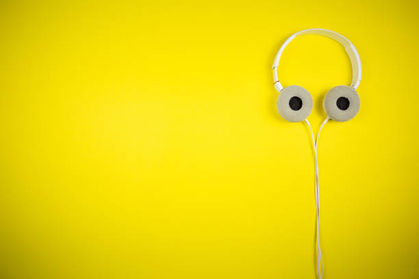 istock White audio headphones with a 3.5 mm wire on a yellow background 1219455235