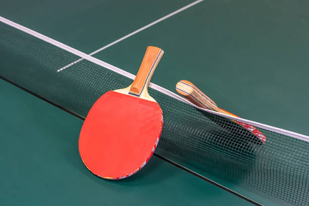 istock red racket for playing ping pong on the background of the separation grid 1219455435