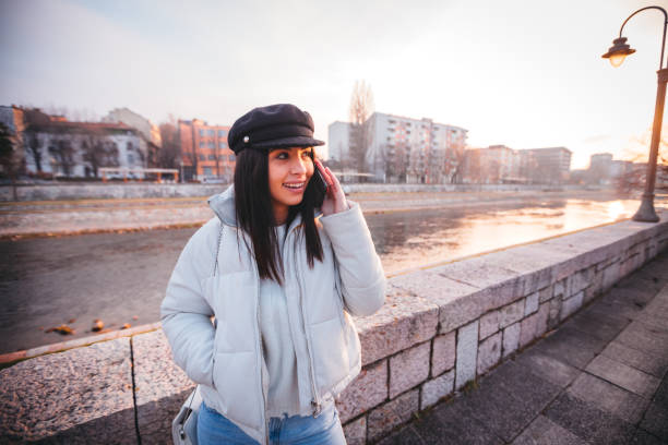 istock Smiling girl walking by the river and using her phone 1219456585