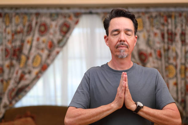 istock COVID-19 Home Exercise Man Does Yoga Heart Center Eyes Closed MS Right 1219457322