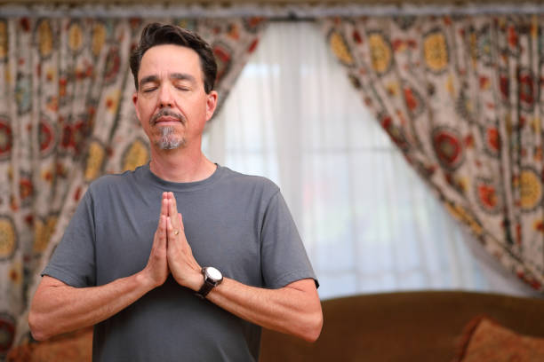 istock COVID-19 Home Exercise Man Does Yoga Heart Center Eyes Closed MS Left 1219457352