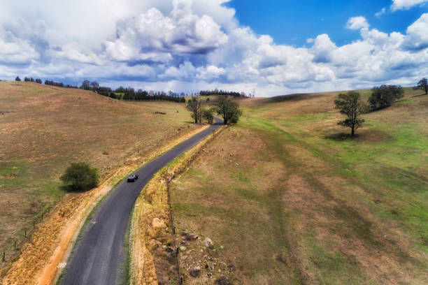 Gravel dirt road up and around a bend on a road through the New South Wales countryside in Australia