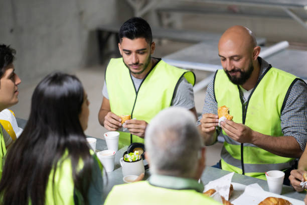istock Team of people at a construction site enjoying a snack while smiling and talking 1219457450