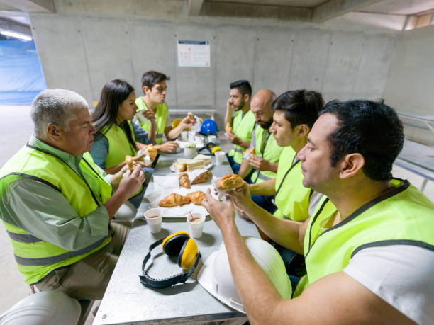 istock Team of people working at a construction site taking a break enjoying a snack and coffee 1219457461