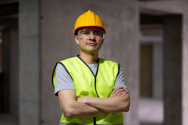 istock Confident young man working at a construction site smiling at camera with arms crossed 1219457468
