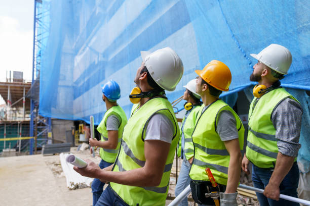 istock Team of people working at a construction site looking up 1219457508