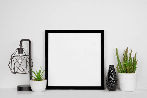 istock Mock up black square frame with home decor and potted plants with white shelf and wall 1219457549