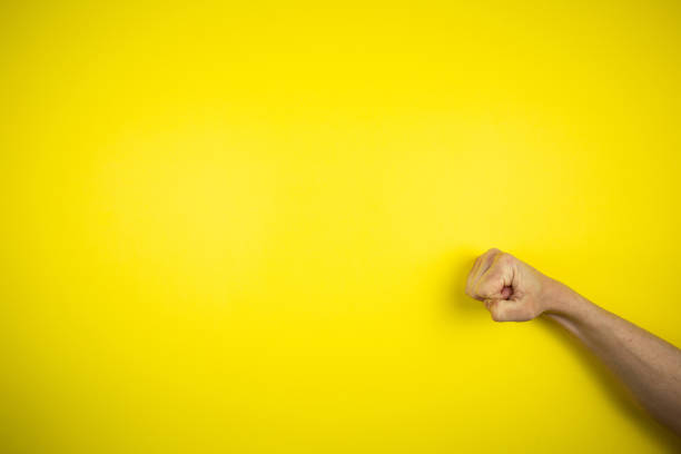 istock Punch, knock hand gesture on a yellow background 1219458582
