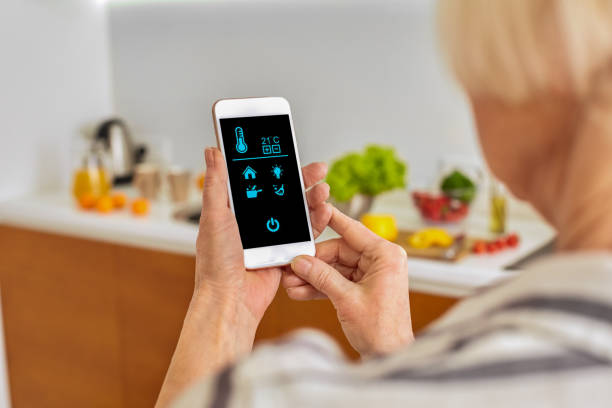 istock Retirement woman regulate temperature in room and using modern smartphone with smart house app 1219462056