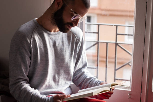 istock Concentrated bearded man reading a book during the quarantine 1219462508