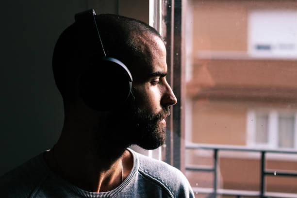 istock Handsome man wearing headphones next to the window 1219462569