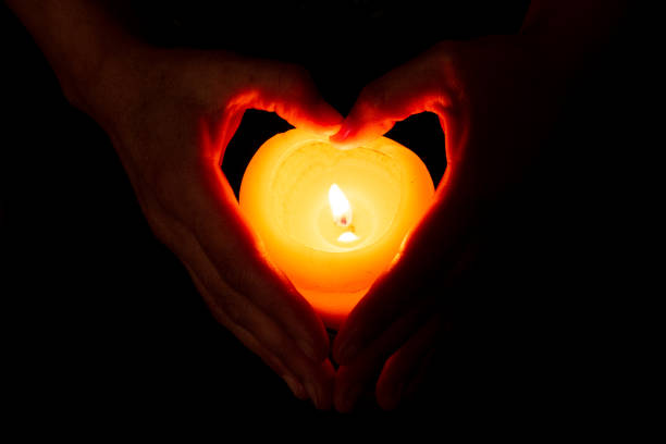 istock heart formed with hands and a burning candle 1219463205
