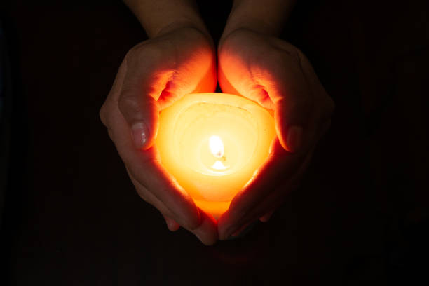 istock heart formed with hands and a burning candle 1219463237