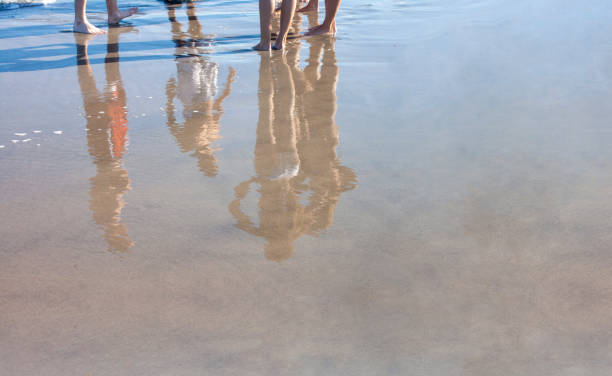 istock young bathers in bathing suits reflection on freshly wet sand 1219469251