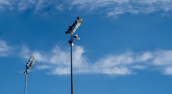 tall pole high powered event lights during blue day sky with white clouds