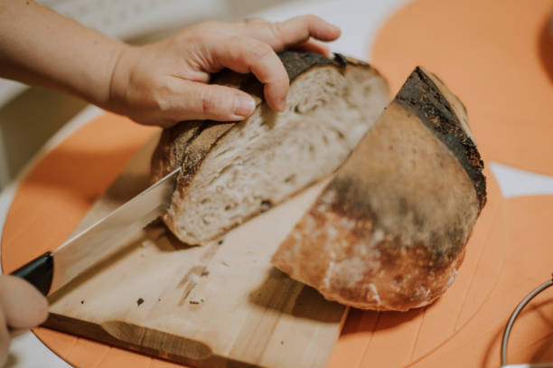 istock a pair of human hand using kitchen knife cutting bread sourdough on table 1219469957