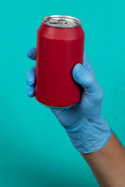 istock hand with protective gloves holding red can of soda 1219469973