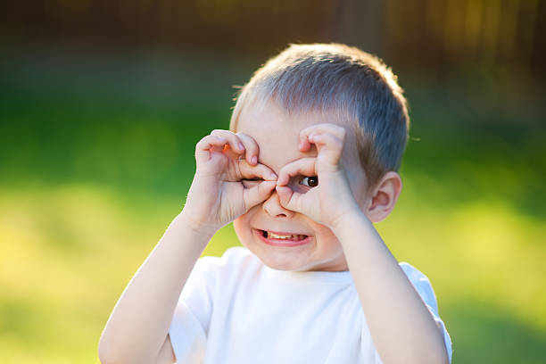 istock Little kid hides making a mask with his hands 121947571