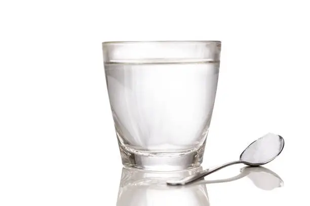 Photo of ORS or oral rehydration salt with glass of water and spoon