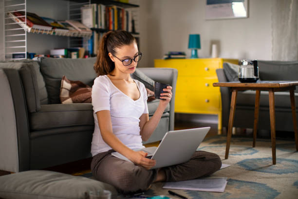 istock Young woman using a laptop at home 1219479143