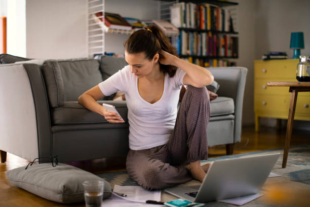 istock Young woman using a phone at home 1219479882