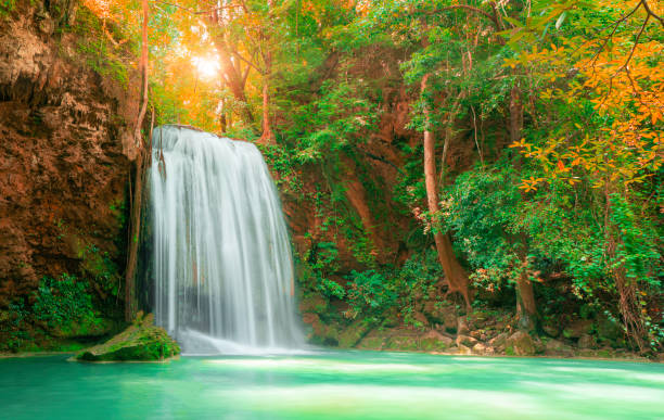 belle chute d’eau avec la lumière du soleil dans la forêt d’automne au parc national d’erawan, thaïlande, - national park kanchanaburi province thailand waterfall photos et images de collection