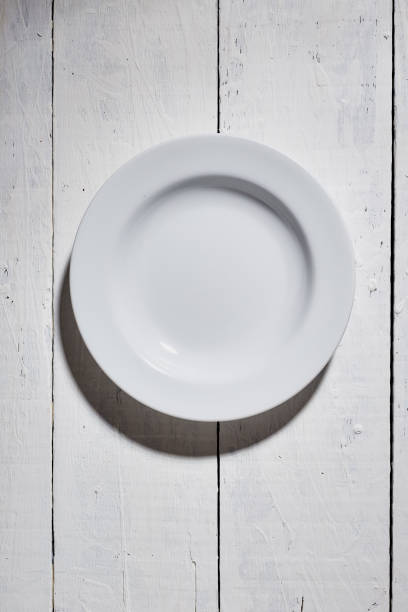 istock top view of blank plate on white wooden table. for using with text and signs. 1219480599