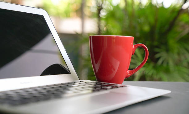 istock Computer laptop with red cup. Outdoor background. 1219487402